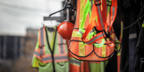 Orange safety vests hanging at a worksite