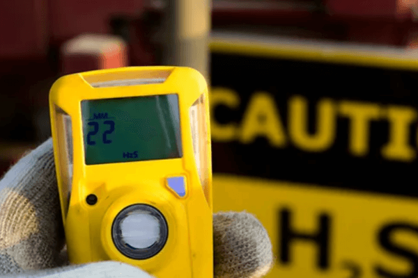 An Industrial Safety Solutions worker holding a meter the detects levels of atmospheric gas.